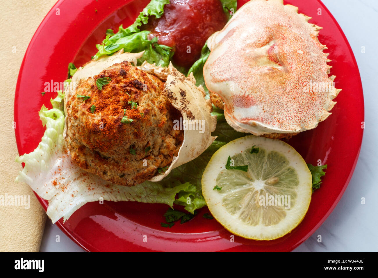 Les carapaces de crabe farci garni de laitue romaine et tranches de citron avec la sauce cocktail Banque D'Images