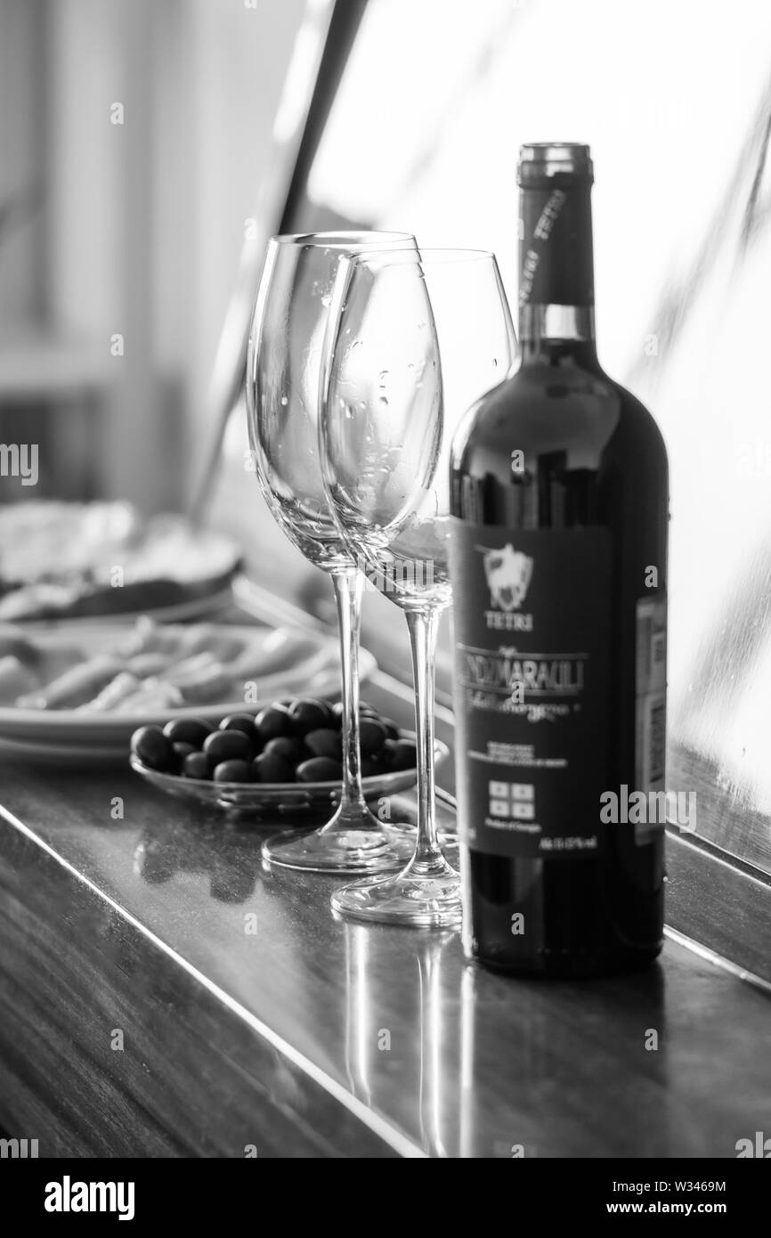 Dîner romantique et le vin rouge. Les plats sont sur le piano : poisson, les olives, les verres. bw, vertical Banque D'Images