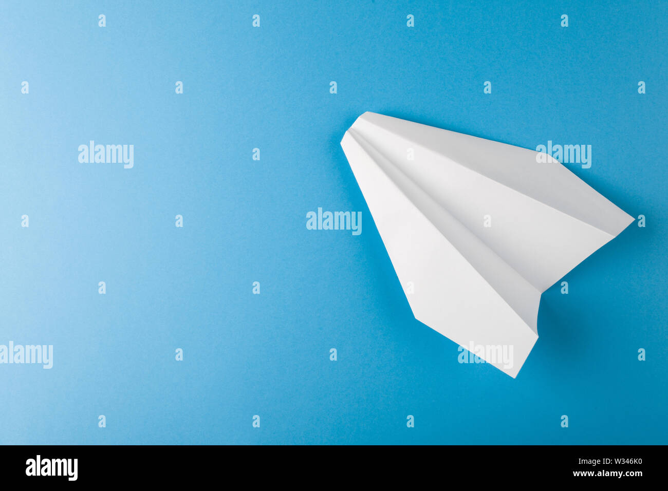 Mise à plat de l'avion en papier blanc et le papier blanc sur fond de couleur bleu pastel Banque D'Images