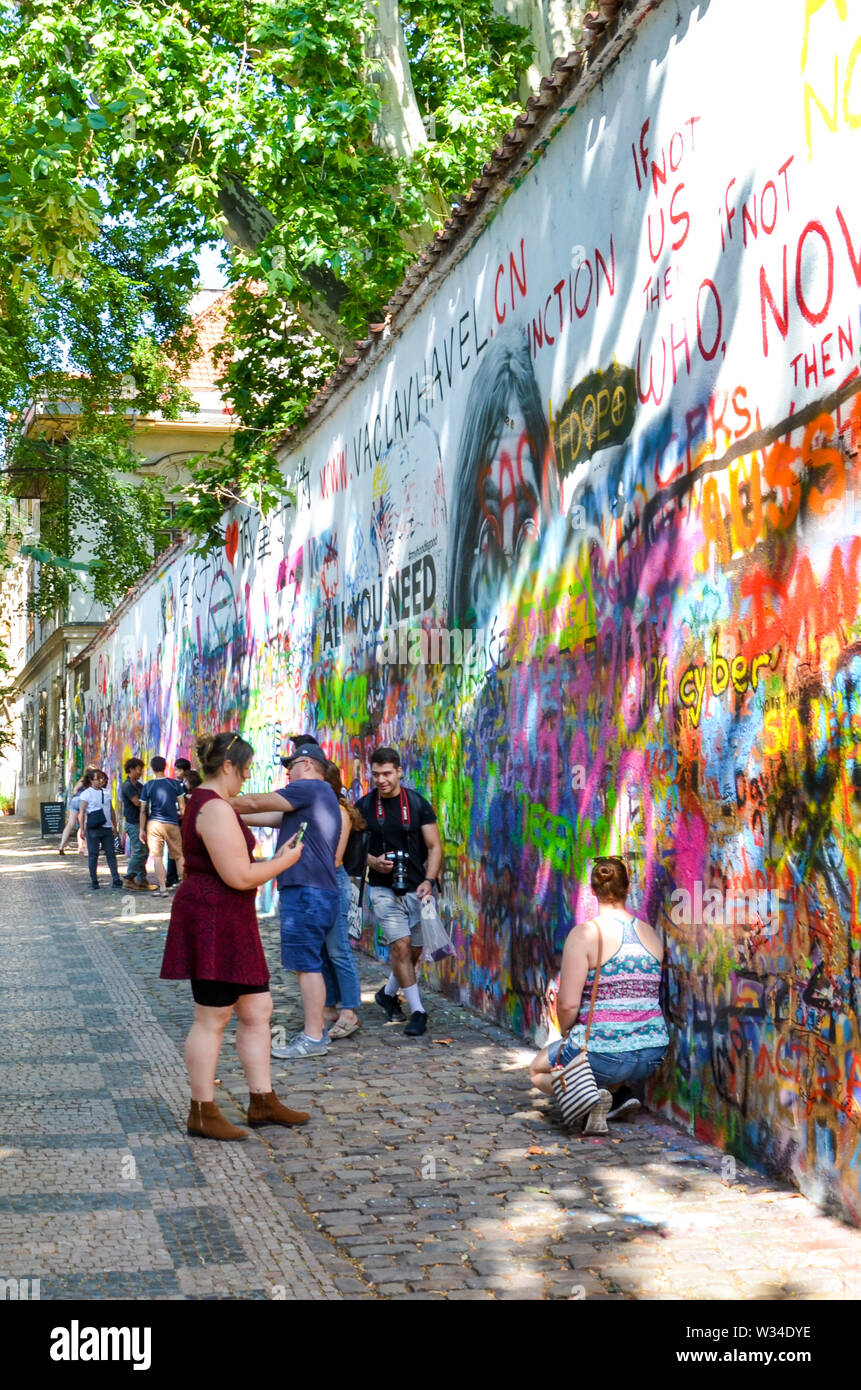 Prague, République tchèque - 27 juin 2019 : les touristes de prendre des photos en face de la célèbre John Lennon Wall dans le centre de la capitale tchèque. Mur de graffiti inspiré par le célèbre artiste. Lieu touristique populaire. Banque D'Images
