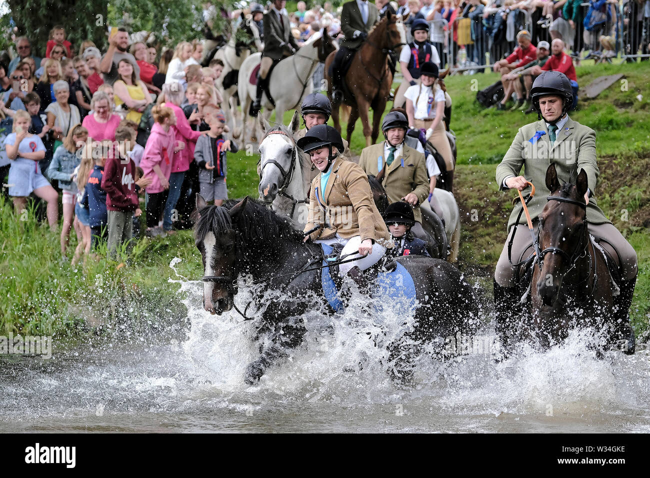 Jedburgh, ÉCOSSE - 12 juillet : Jethart CallantÕs - Festival Festival de la journée quelques 250 cavaliers making a splash comme ils l'eau ford Jed durant la Jethart Callant's Festival, un festival annuel, une partie de l'équitation commun saison, le jour du festival le vendredi 12 juillet 2019 à Jedburgh. (Crédit : Rob Gray / Alamy Live News) Crédit : Rob Gray/Alamy Live News Banque D'Images