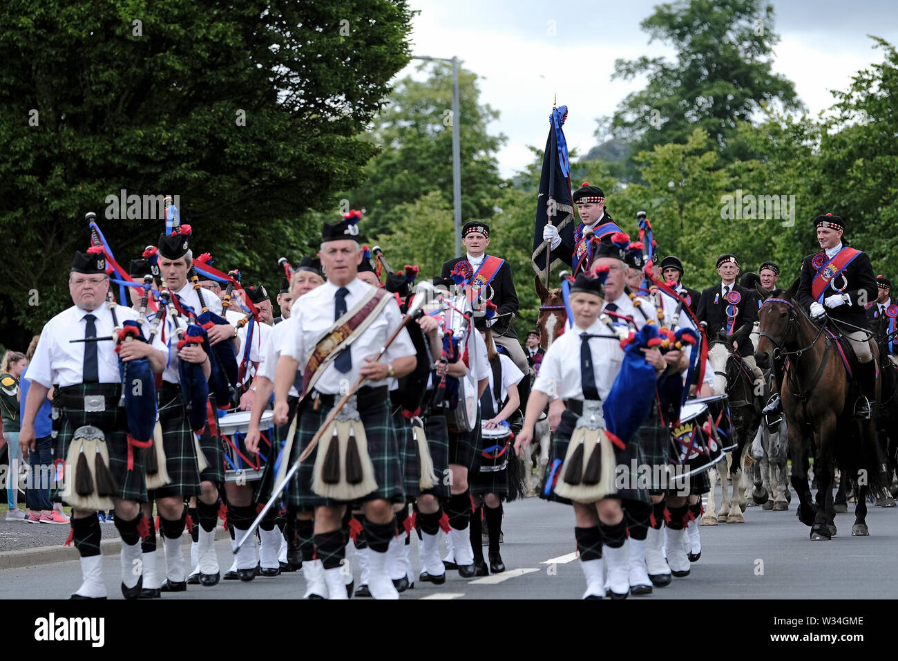 Jedburgh, ÉCOSSE - 12 juillet : Jethart CallantÕs - Festival Festival jour mener par Jedburgh Pipe Band, 2019 Jethart Callant Euan Munro. Herald Robert Reid, Main Gauche Homme Brodie, Irving Main Droite Homme Nick Arnold, sur l'A68 pendant la Jethart Callant's Festival, un festival annuel, une partie de l'équitation commun saison, le jour du festival le vendredi 12 juillet 2019 à Jedburgh. Plus de 250 partisans montés ont pris part à la balade (Photo de Rob Gray / offres de crédit) : Rob Gray/Alamy Live News Banque D'Images