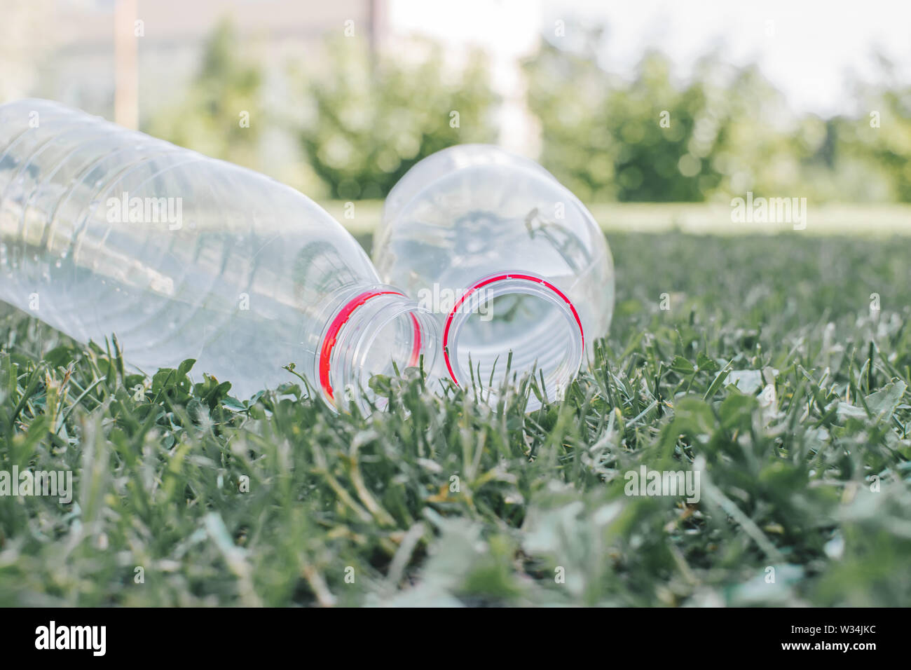 Deux bouteilles de plastique sur le fond de l'herbe. La séparation des déchets concept. Banque D'Images