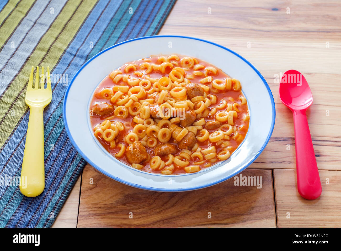 Les repas en conserve avec des boulettes de viande et des anneaux spaghetti ustensiles colorés Banque D'Images