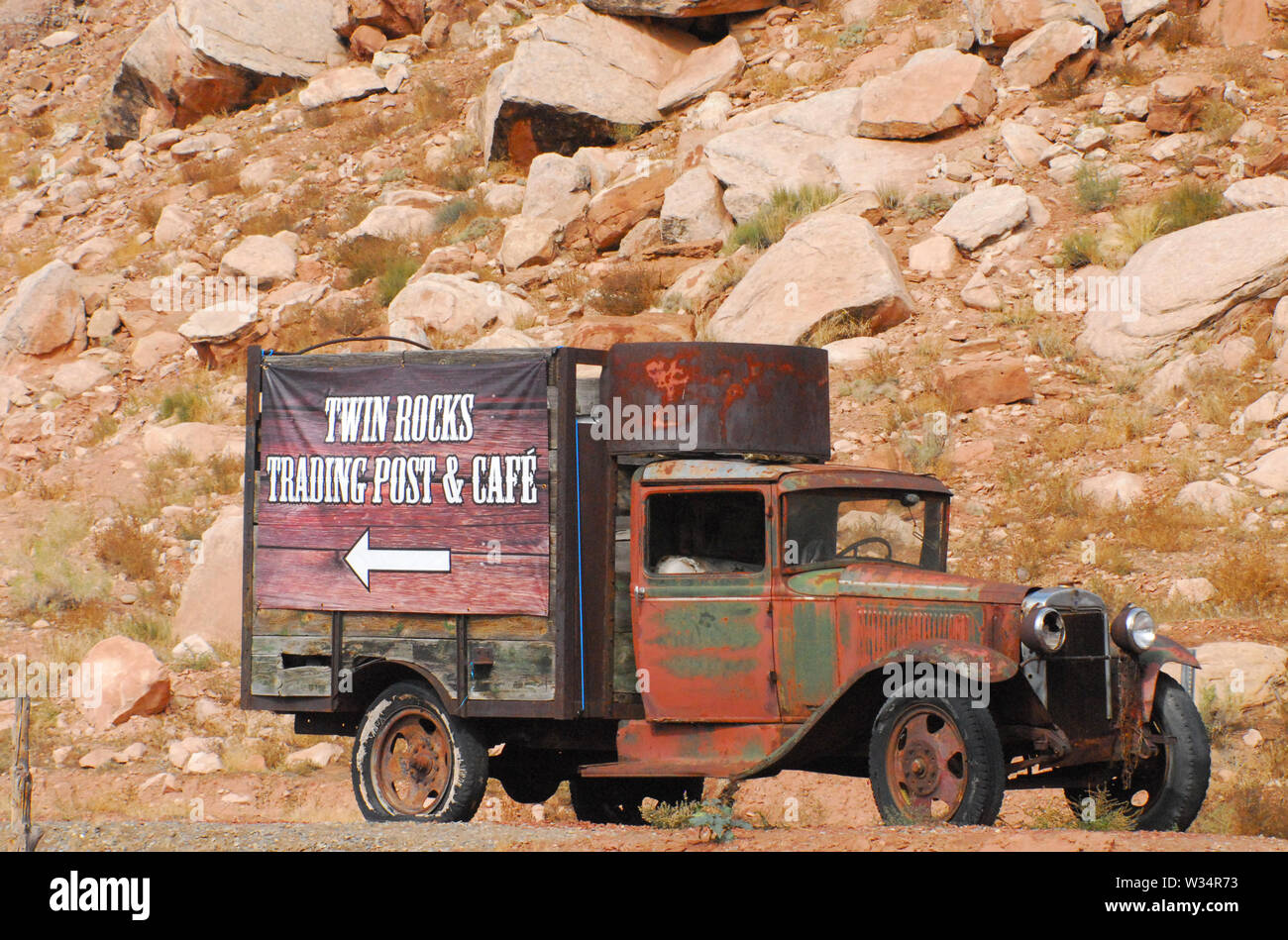 Une ancienne, rouillé out chariot avec un panneau publicitaire de la Twin Rocks Cafe à Bluff, Utah, USA Banque D'Images