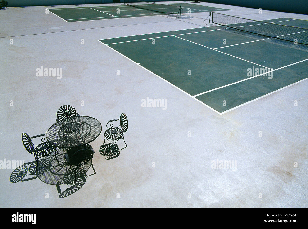 USA. La Californie. Siméon parc du château. Vue extérieure de la haute cour de tennis et vide table et chaises. Banque D'Images
