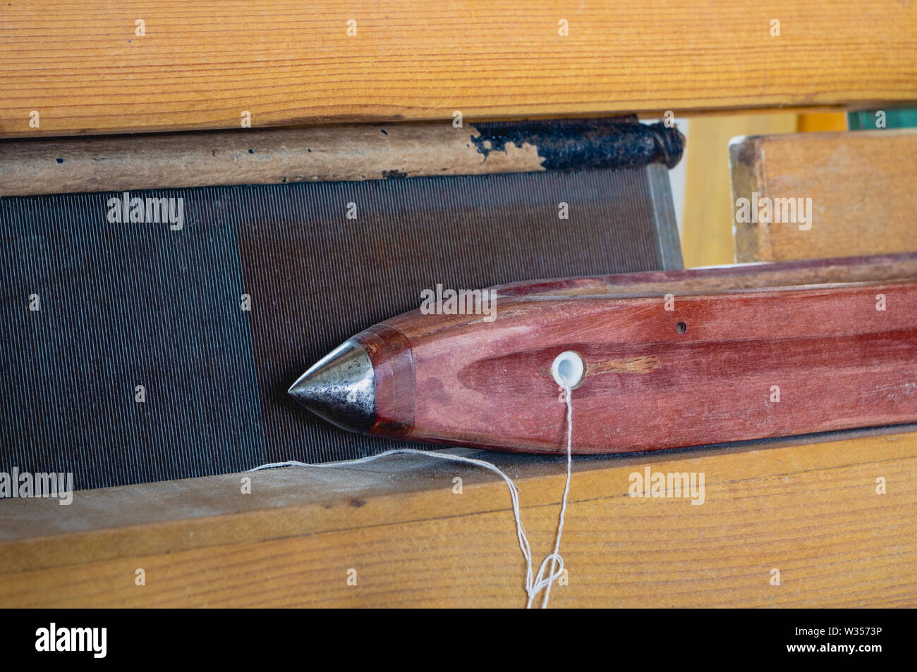 Navette de tissage avec capuchon métallique et fil prêt à tisser sur un métier à tisser à la main en bois Banque D'Images