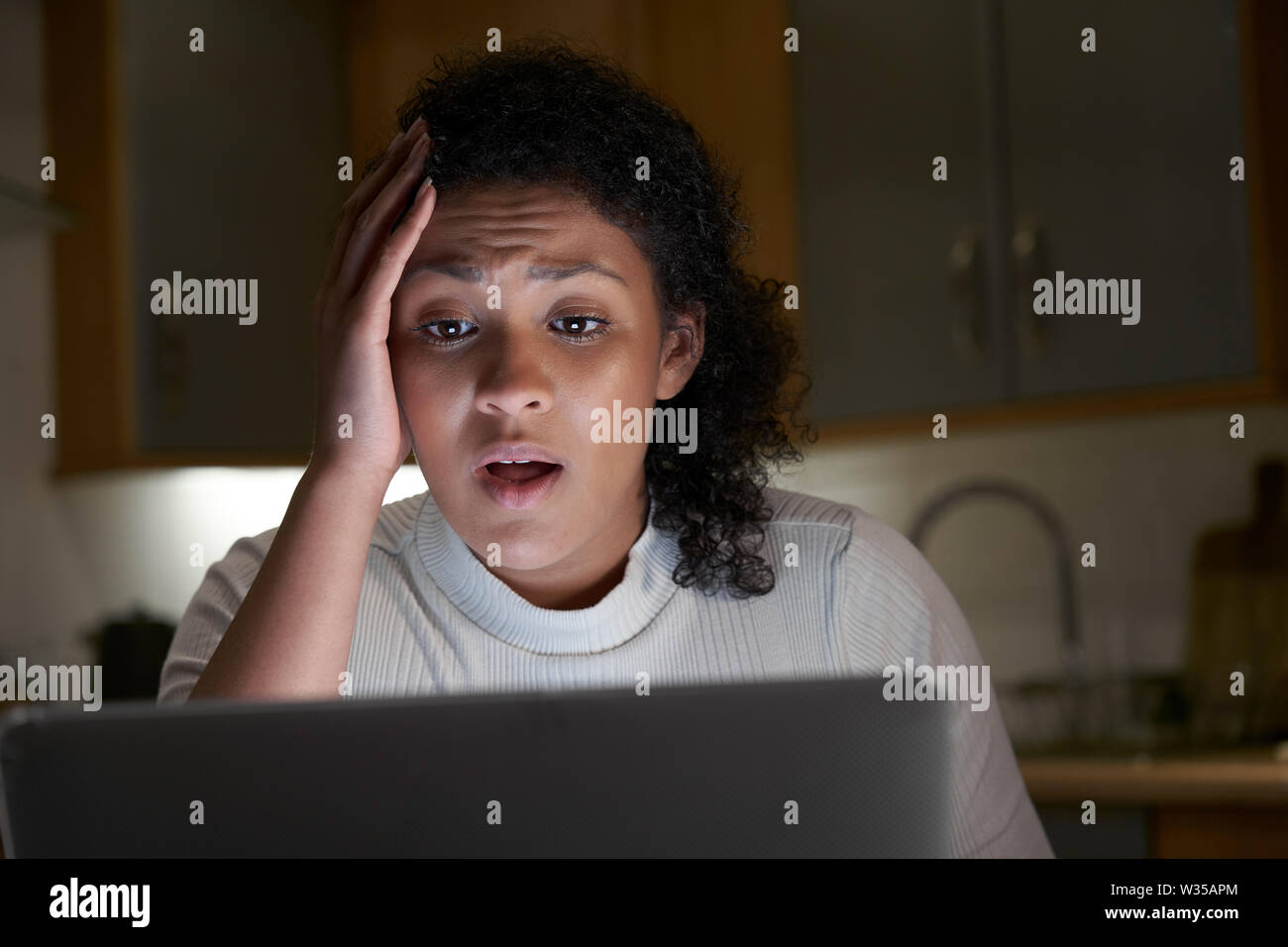 Femme malheureuse à la maison avec l'ordinateur de l'intimidation en ligne sur les médias sociaux Banque D'Images