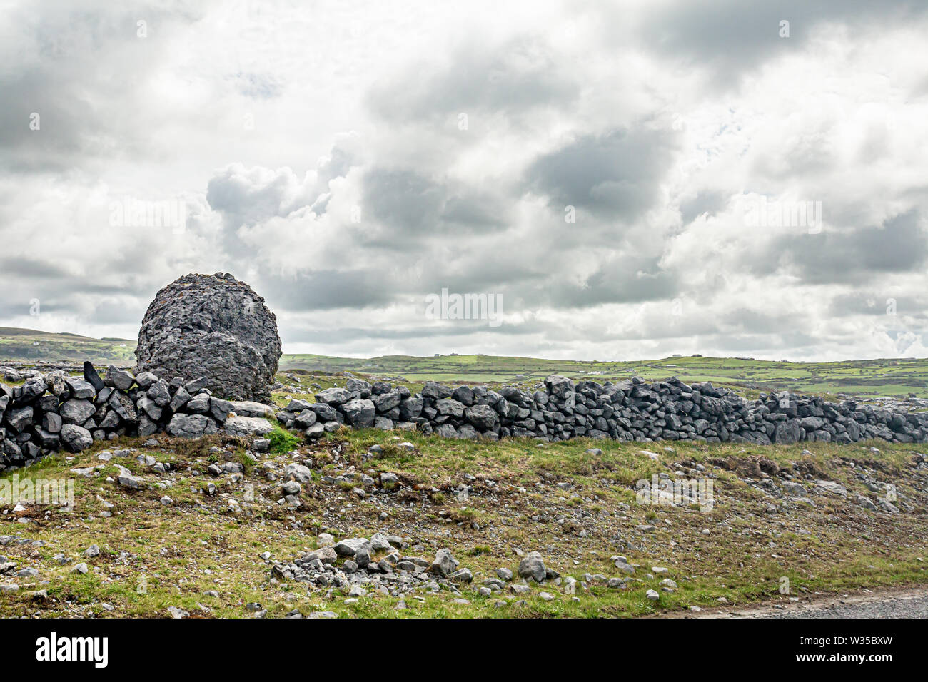 Beau paysage irlandais dans la vallée d'un Caher pierre géant à côté d'une clôture en pierre, le Burren, façon sauvage de l'Atlantique, merveilleux printemps jour nuageux Banque D'Images