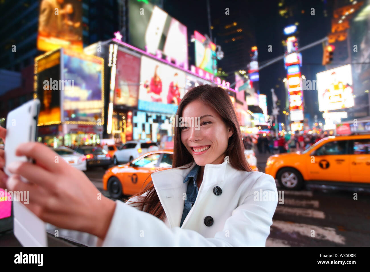 Happy woman tourist taking photo photo avec le comprimé dans la ville de New York, Manhattan, Times Square. Voyageur fille joyeuse et selfies prendre happy smiling. Asiatiques multiethniques Caucasian woman dans son 20s. Banque D'Images