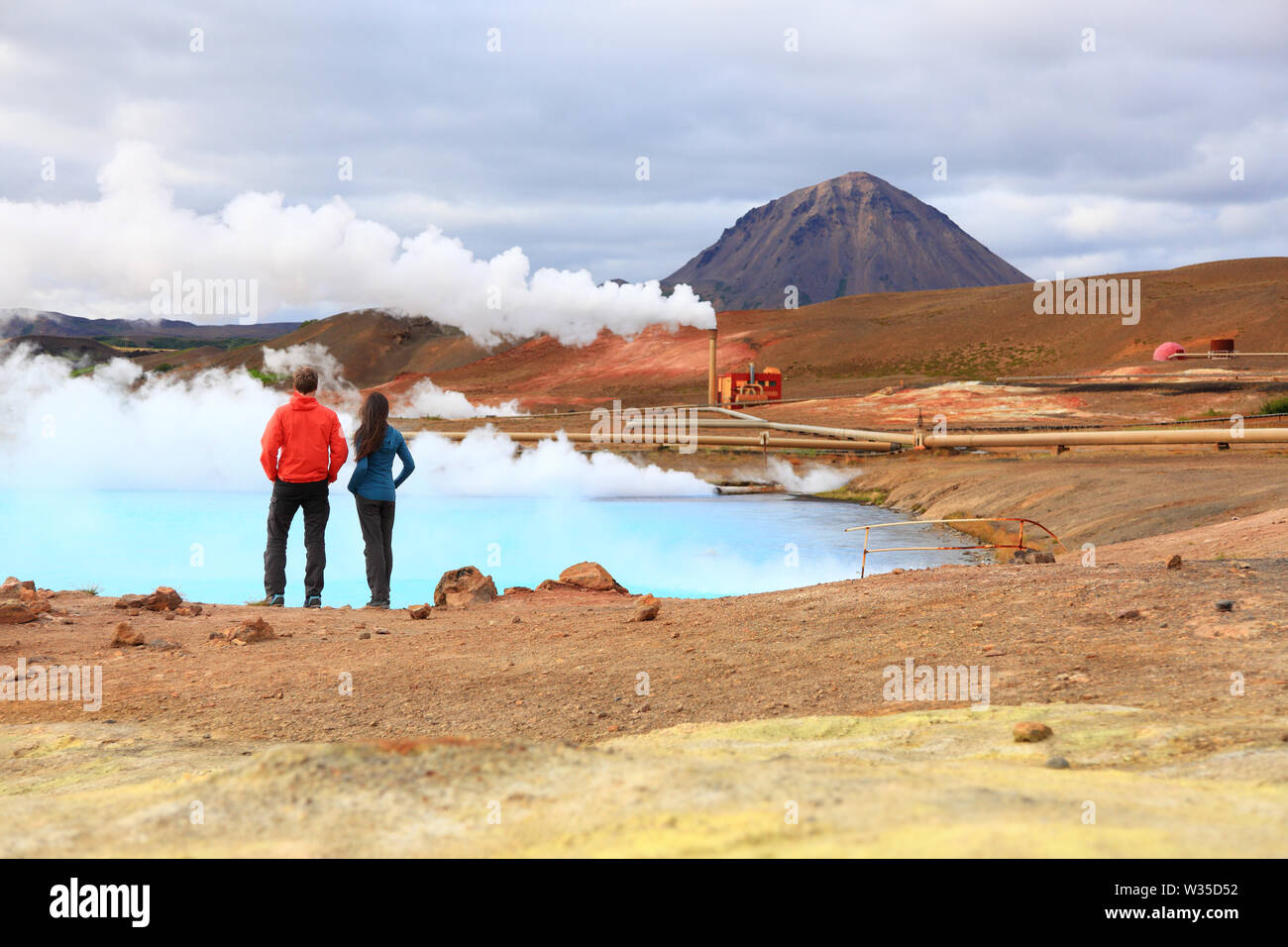 Les gens de voyage Islande par l'énergie géothermique centrale et en ressort chaud Namafjall dans le lac Myvatn. Couple sur les voyages dans la nature islandaise paysage, Route 1 Ring Road. Banque D'Images