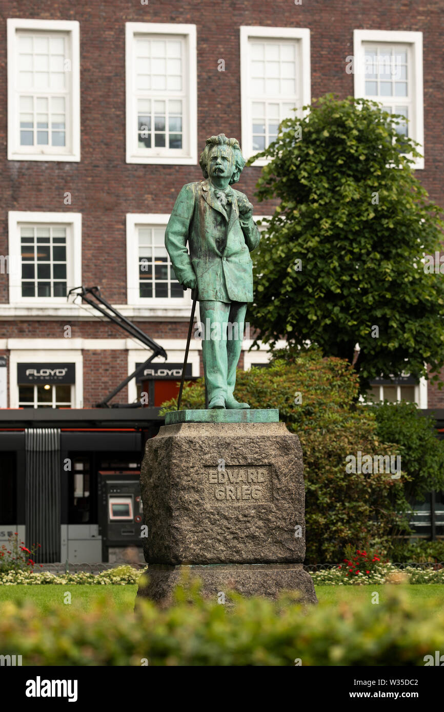 La statue de Edvard Grieg sur Olav Kyrres gate dans le centre de Bergen, en Norvège, avec un tramway passent dans le fond. Banque D'Images