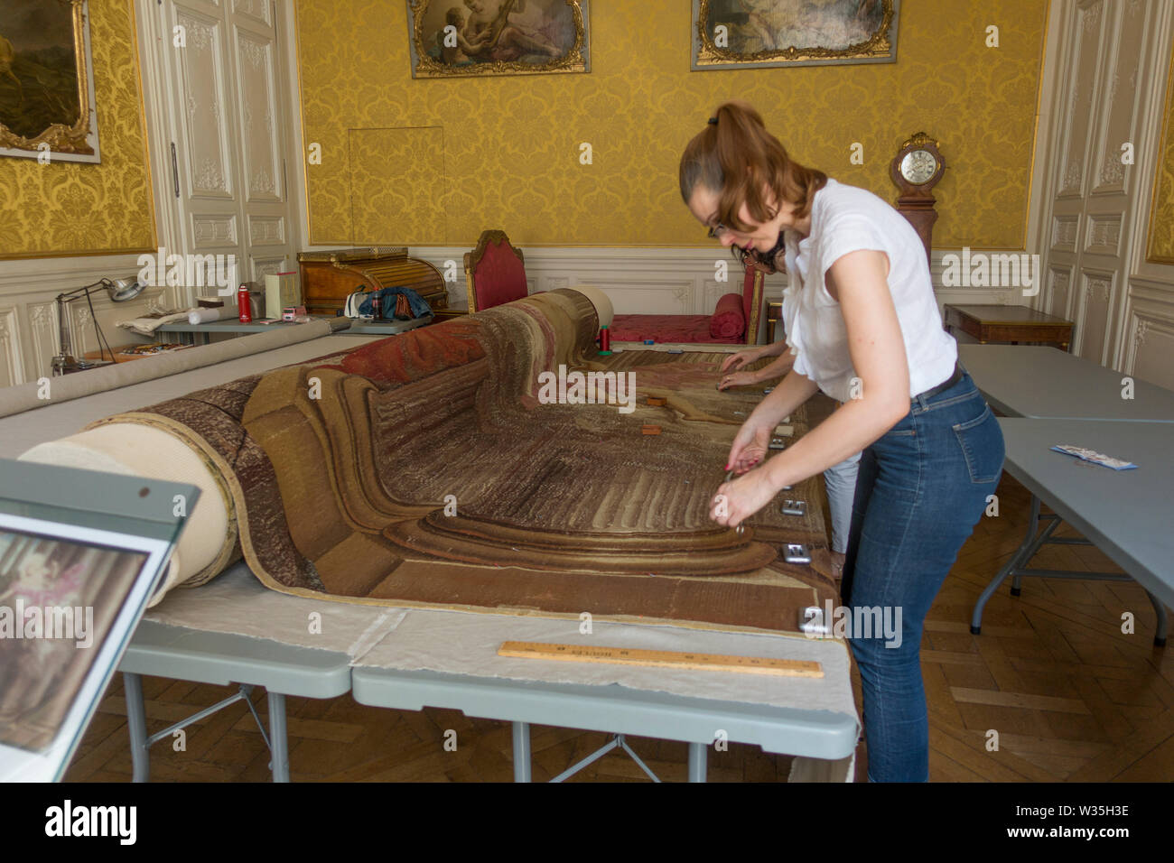 Deux femmes la réparation d'un tapis anciens, à l'intérieur de l'édifice des Archives nationales, l'ancien hôtel de Soubise Banque D'Images