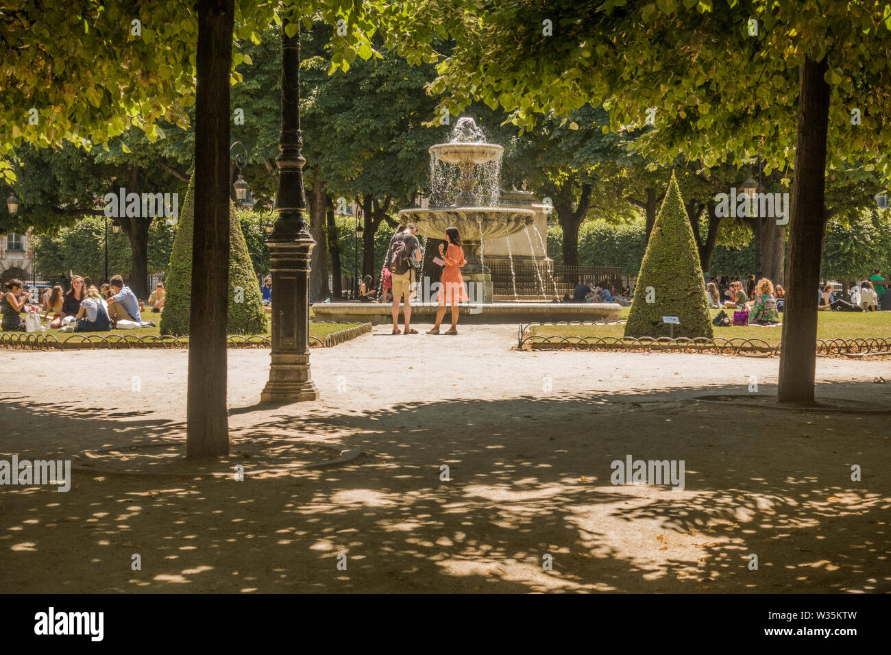 Les touristes en été à la vague de chaleur, de la Place des Vosges, Paris, France. Banque D'Images