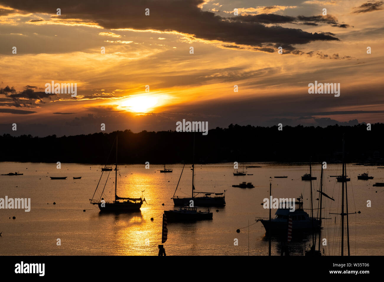 Voiliers amarrés au coucher du soleil un soir d'été à Boothbay Harbor Maine. Banque D'Images