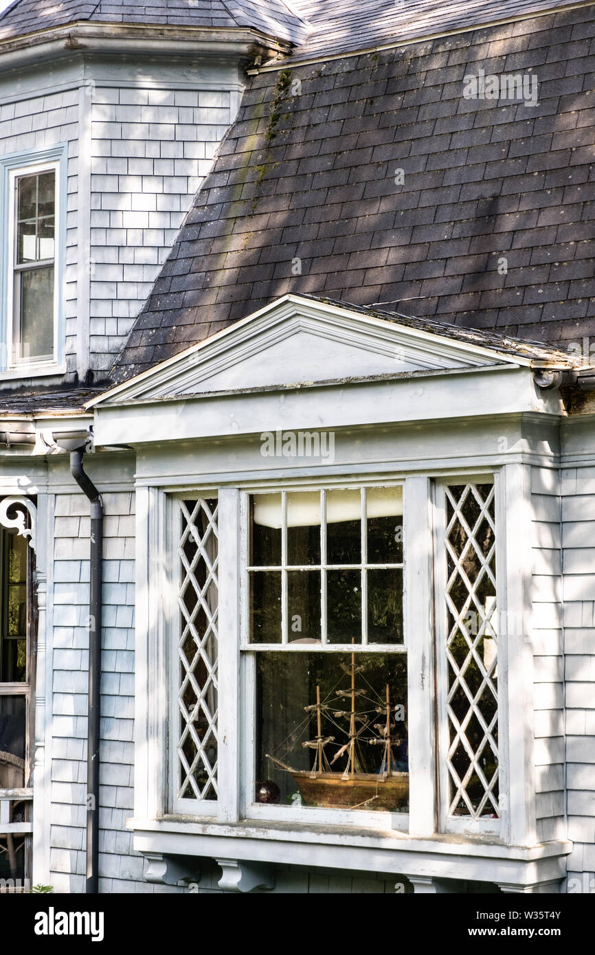 Un voilier modèle dans les fenêtres d'une maison traditionnelle dans le Maine à Five Islands Harbour à Georgetown, dans le Maine. Banque D'Images