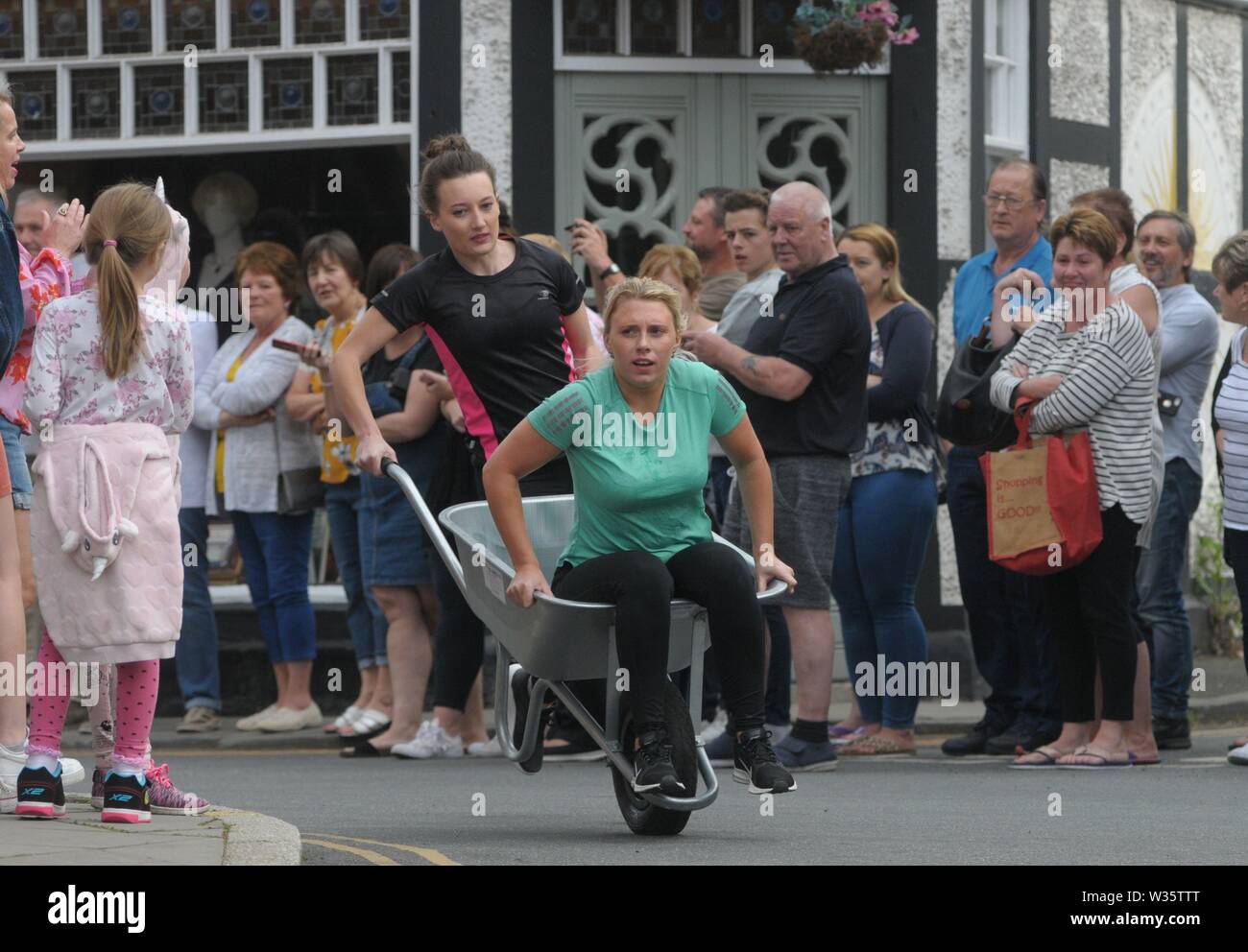 Presteigne, Powys, Wales, UK, 12 juillet 2019. Freddie Mercury, graisse, mexicains et de l'ennuie le sosie de Mario n'étaient que quelques-uns des candidats colorés qui ont pris part à cette course de brouettes Presteigne années. Bordée de spectateurs dans les rues de la petite ville de regarder plus de 20 contestans les une demi-pinte de bière à 7 arrêts à l'événement annuel. Venus s'est précipité sur un demi-mile à travers les rues de la ville au milieu du Pays de Galles pour recueillir de l'argent pour le carnaval et les pompiers locaux. s. Crédit : Andrew Compton/Alamy Live News Banque D'Images