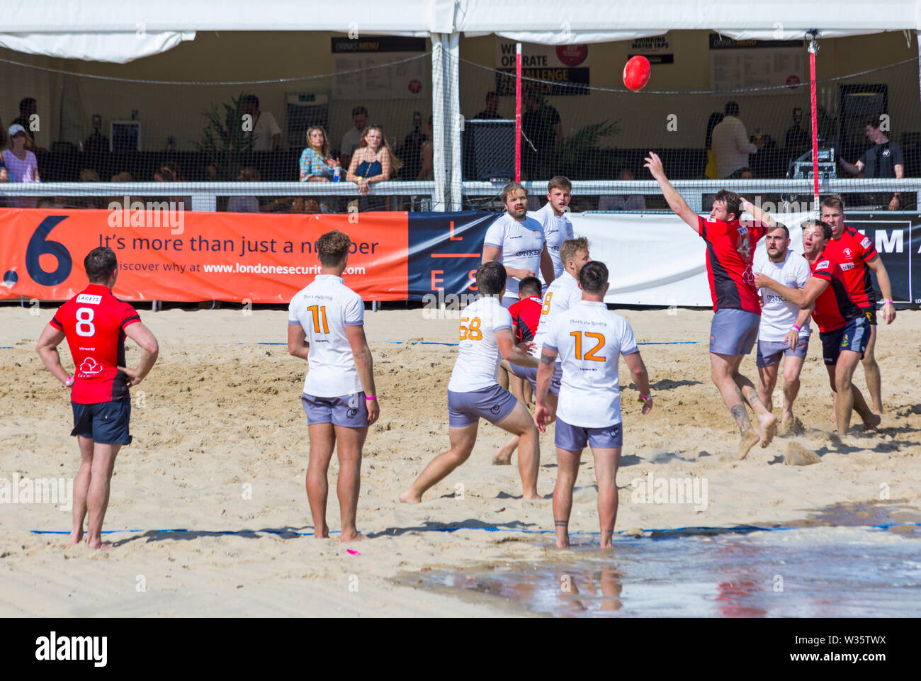 Bancs, Poole, Dorset, UK 12 juillet 2019. Le Sandpolo Beach Polo Championships britannique est en cours à la plage de Sandbanks Poole, sur une chaude journée ensoleillée. Le plus grand événement beach polo dans le monde, l'événement de deux jours a lieu le vendredi et samedi, en tant que visiteurs, chef de la plage pour voir l'action. Exposition Sandscrum cinq-a-side beach rugby. Credit : Carolyn Jenkins/Alamy Live News Banque D'Images