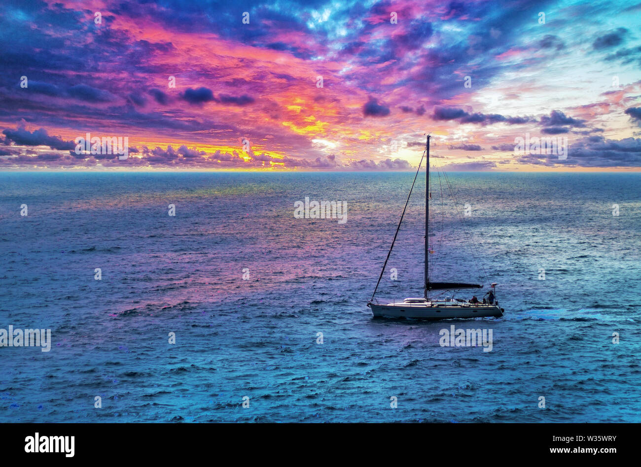 Bateau à voile sur la mer Méditerranée au coucher du soleil. Ciel avec des couleurs d'or pourpre. Banque D'Images