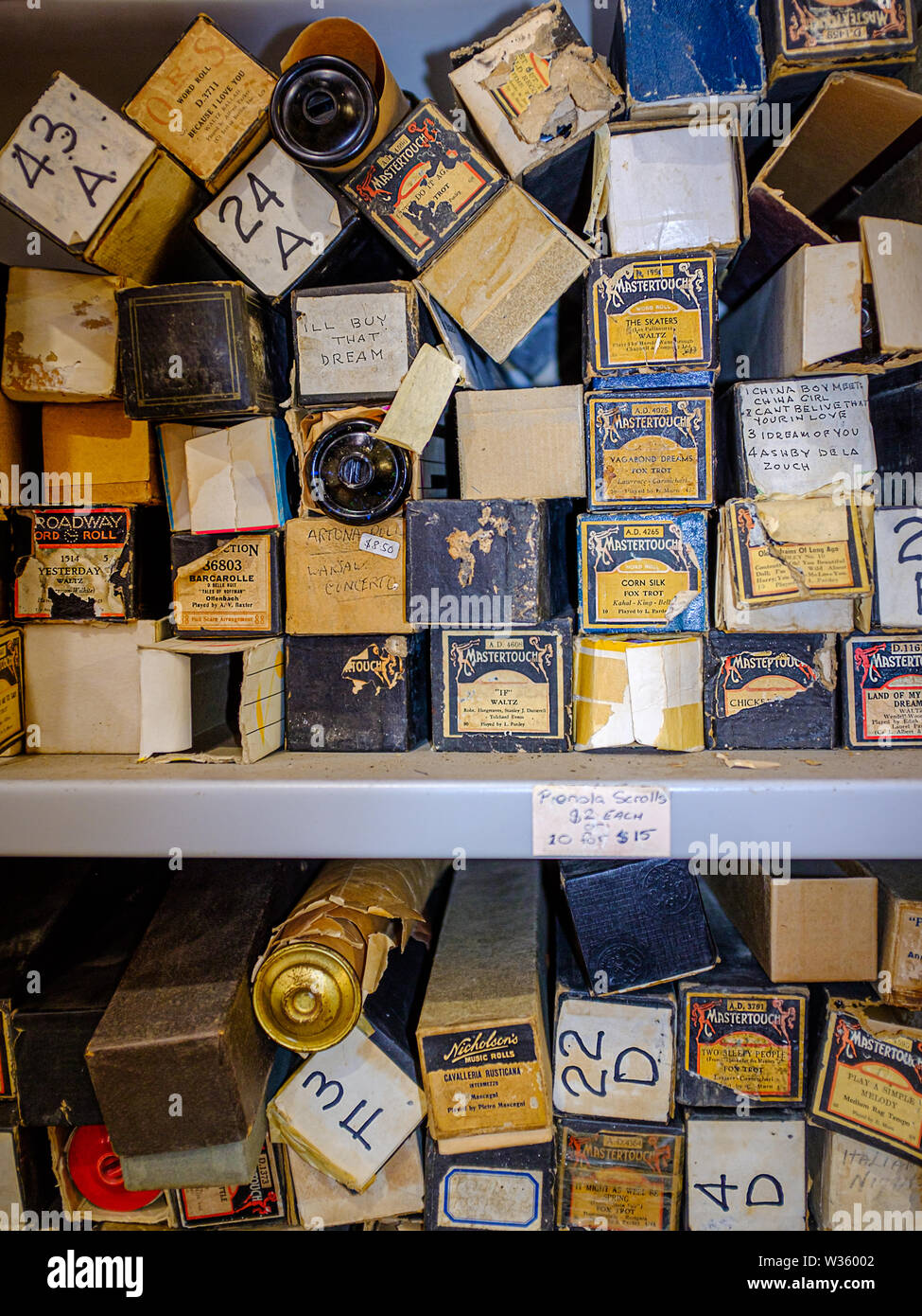 Un tiroir de vieux rouleaux pianola de partitions pour piano d'un Pianola (Technola), un instrument de musique qui joue sur son propre, sur l'affichage en magasin de charité Banque D'Images