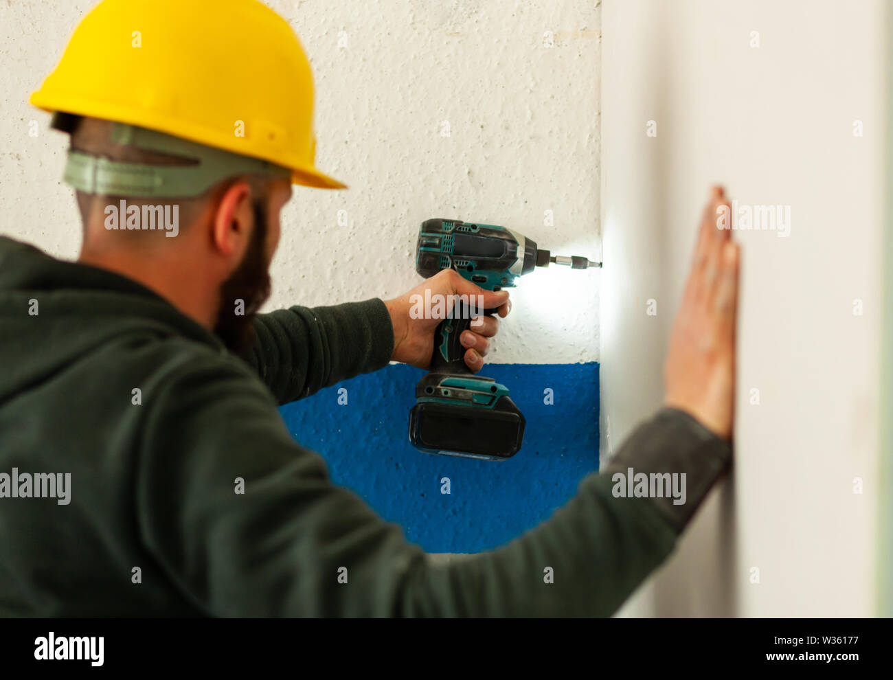 Au travail des travailleurs dans la construction d'un mur de plâtre. Banque D'Images