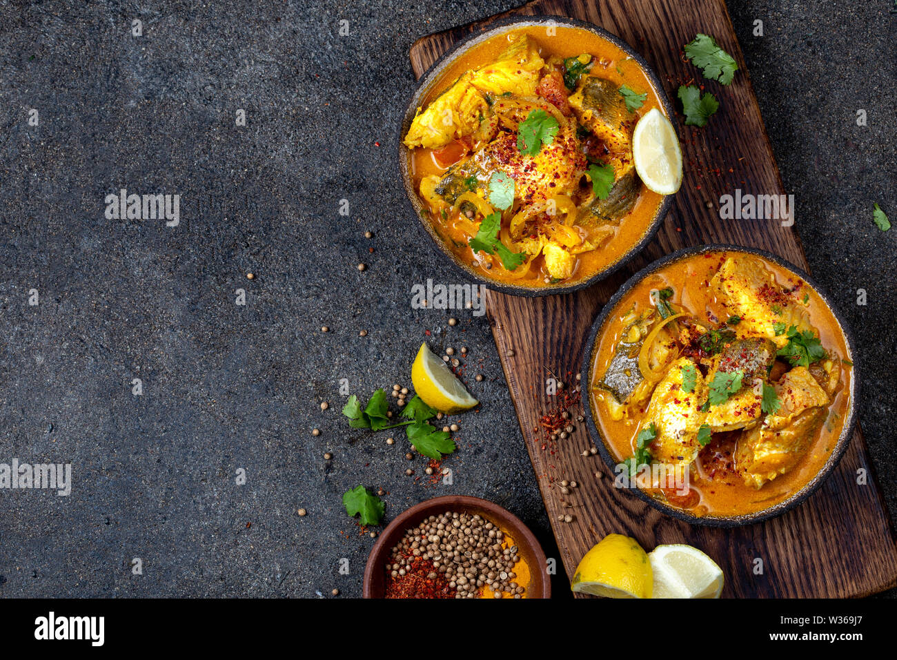Nourriture indienne. KERALA traditionnel curry de poisson avec du pain naan, plaque de fond noir, gris Banque D'Images