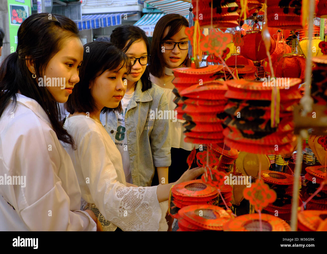 Groupe des belles jeunes filles vietnamiennes visite, amusez-vous, prenez une photo avec des amis la nuit rue lanterne rouge, à dynamique marché plein air Banque D'Images