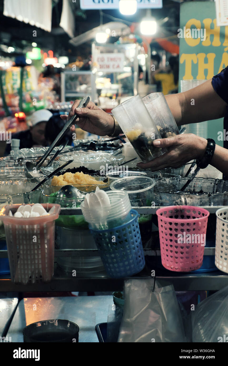 Vietnamienne faire sweet gruel sur panier de nuit de la rue du marché alimentaire, la variété des aliments ingrédients dans bol en verre pour de nombreux types de snack food Banque D'Images