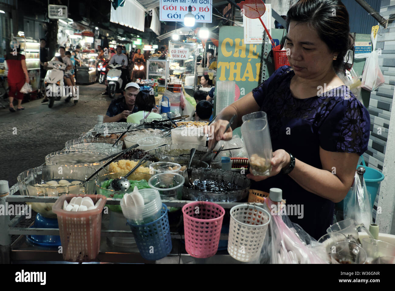 Vietnamienne faire sweet gruel sur panier de nuit de la rue du marché alimentaire, la variété des aliments ingrédients dans bol en verre pour de nombreux types de snack food Banque D'Images
