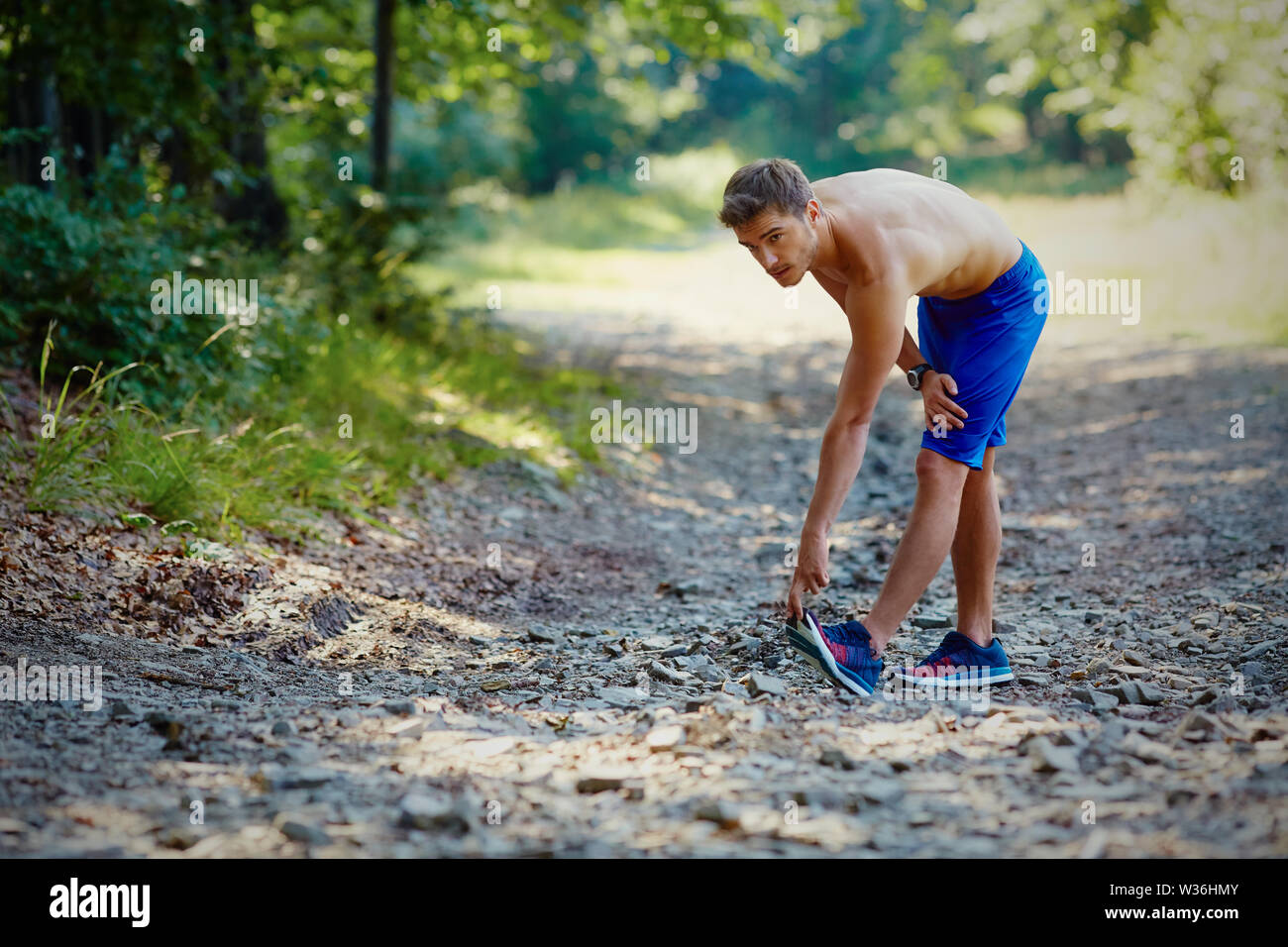 Runner souffre de crampe mollet lors de l'exécution de l'exercice dans la montagne Banque D'Images
