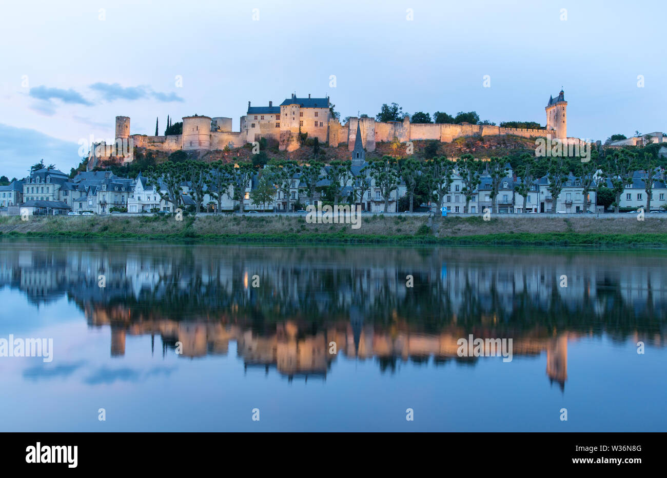 Chinon, France. Crépuscule pittoresque vue de la Vienne à Chinon, avec la Forteresse illuminée Royal et Fort Saint George, dans l'arrière-plan. Banque D'Images