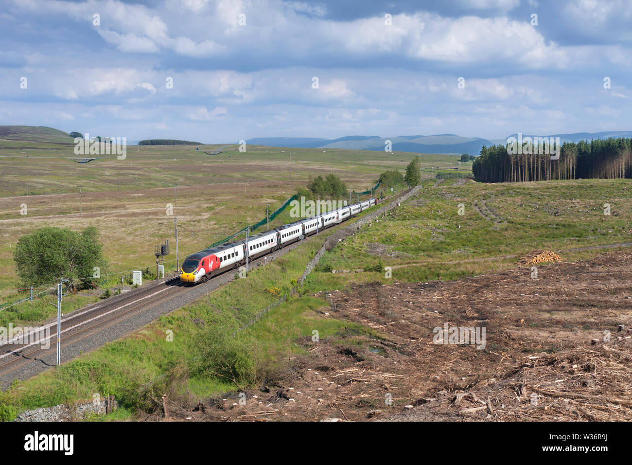 Une classe 390 Virgin trains Pendolino passant Shap Wells sur la ligne principale de la côte ouest dans la région de Cumbria sur l'approche de Shap Sommet. Banque D'Images