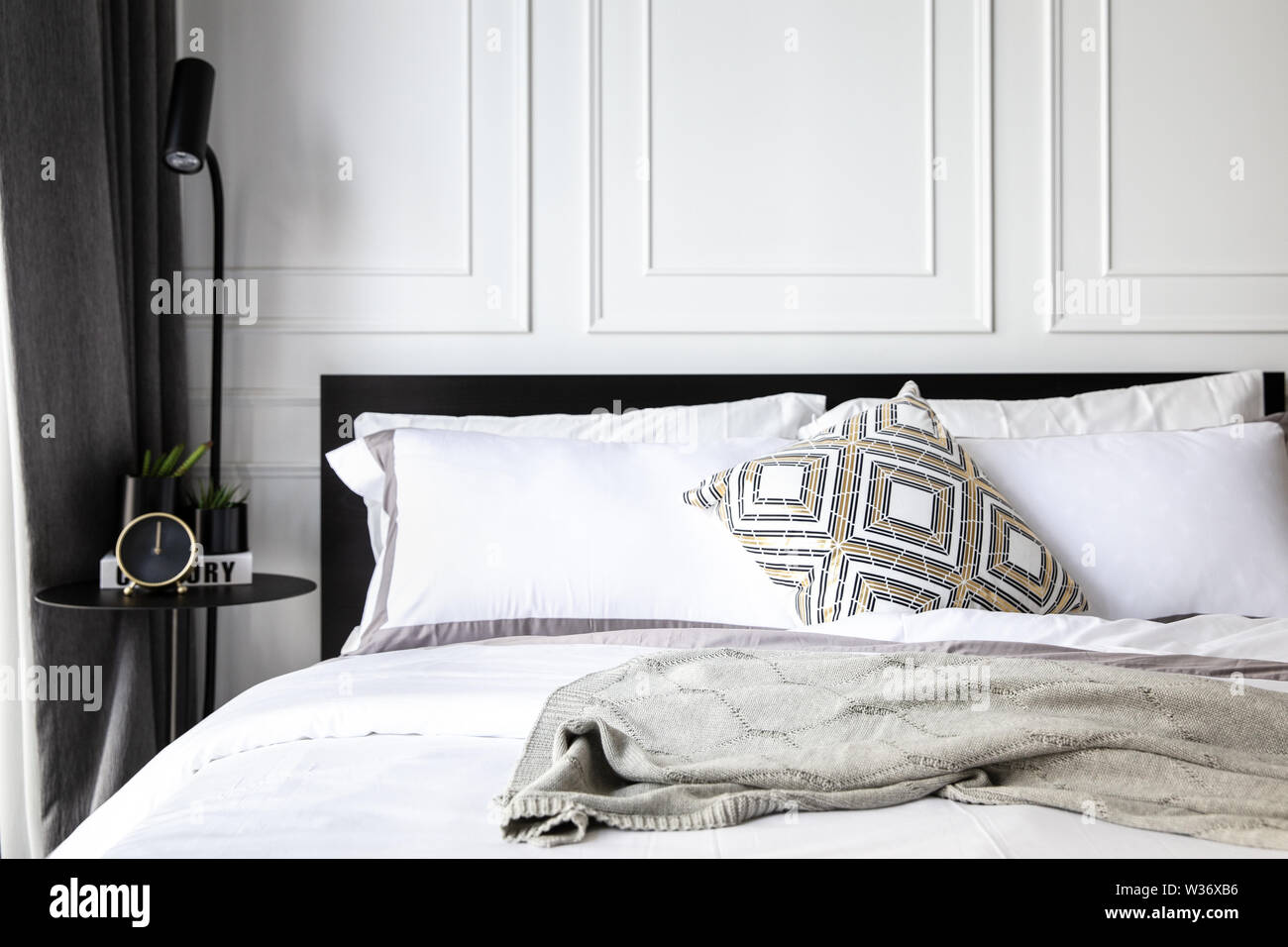 Lit confortable avec des oreillers, drap de lit, couverture de tricot.  Décorées avec loft matal, horloge de table, les petites plantes et belle  conception de lampe. Chambres Photo Stock - Alamy
