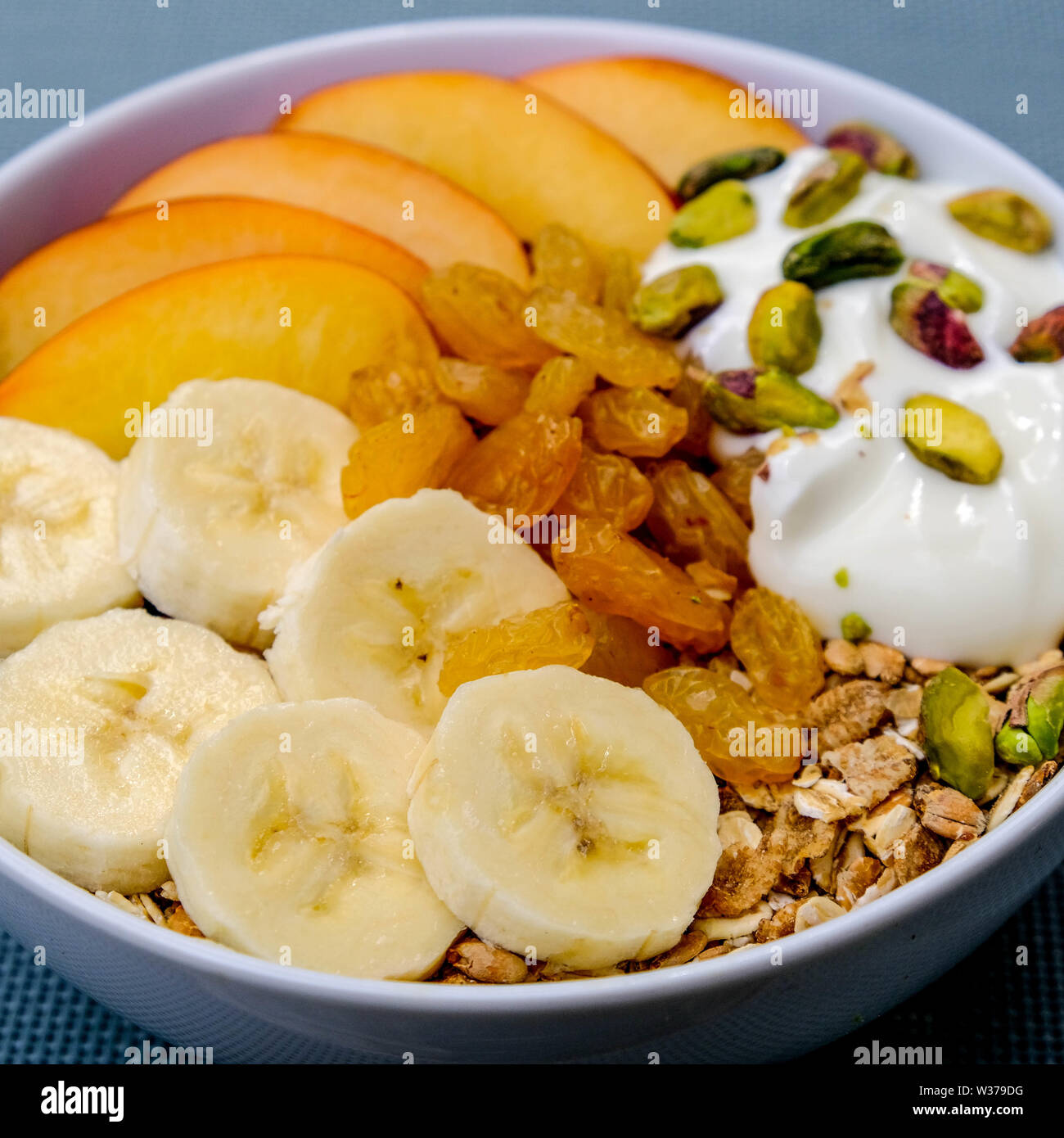 Le petit-déjeuner végétarien sain Bol de fruits et noix muesli avec du yaourt et Golden sultanines Banque D'Images
