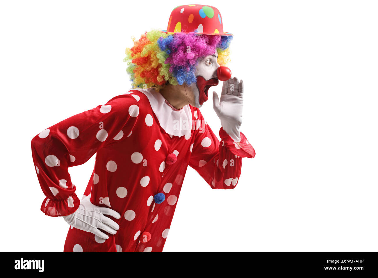 Photo de profil un clown surpris whispering isolé sur fond blanc Banque D'Images