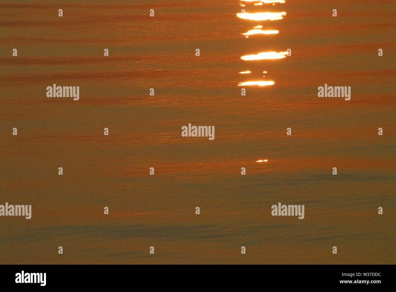 Lever du soleil reflète la couleur orange dans l'image d'un calme océan Atlantique en Floride, USA. Banque D'Images