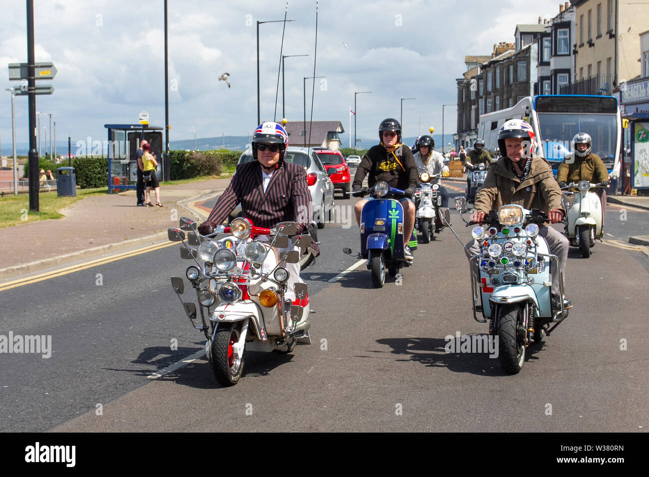 Scooter Rally Ride Out à Lancashire, Royaume-Uni juillet 2019. Morecambe ride à nouveau ; le First Kick Scooter collective et le Vespa Club de Morecambe (COG159) organisent un circuit de rallye dans la station qui a l'honneur d'être un Vespa Club of Britain signant l'événement. Morecambe est de retour sur la carte de scooter avec le premier rallye de scooter approprié depuis les années 1980 ayant lieu. Les scooters rugissaient en ville sur leurs Vespas & Lambrettas se rassemblant à Happy Mount Park avant un rassemblement de masse le long de la promenade du front de mer. Banque D'Images