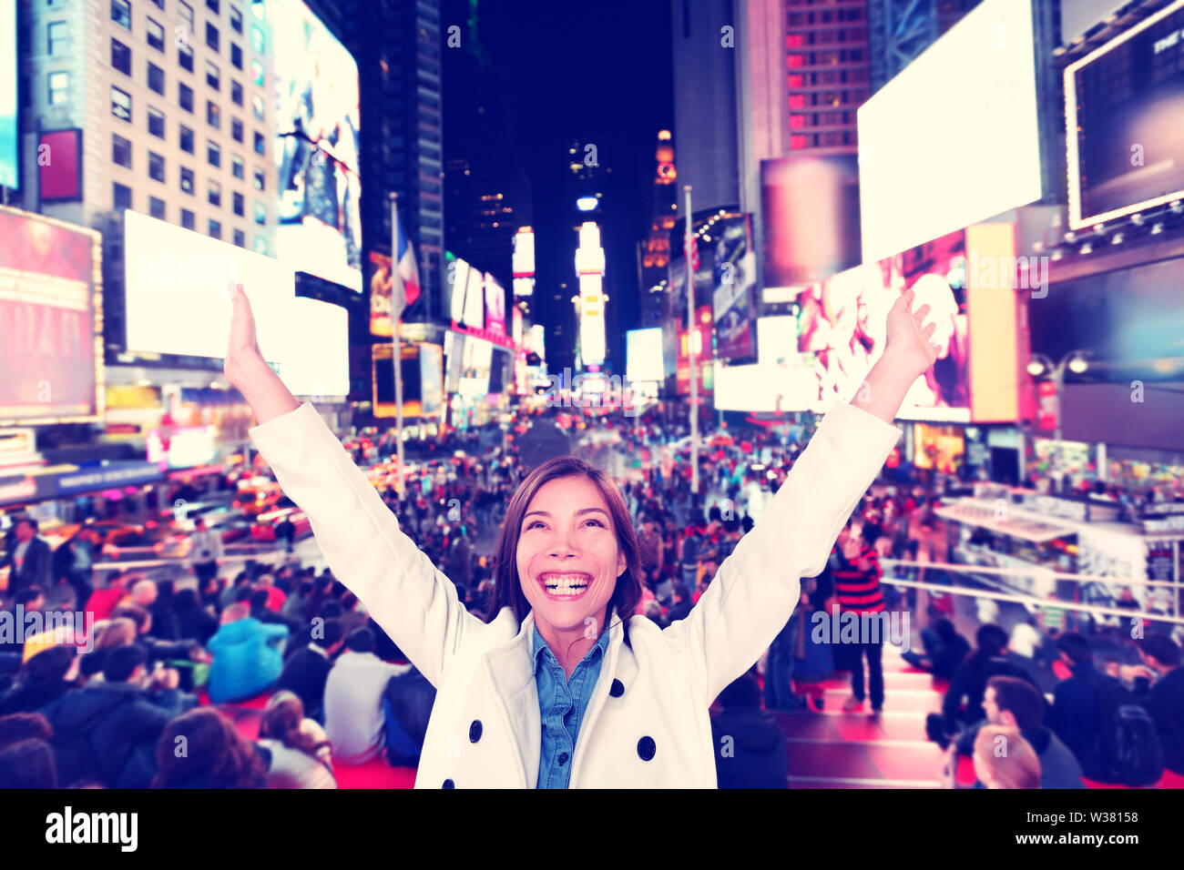 Succès et plaisir- Heureux heureux femme dans la ville de New York, Manhattan, Times Square acclamations joyeuses fête avec bras levés. Joyeux urbains multiethniques du Caucase Asie jeune professionnel dans son 20s. Banque D'Images