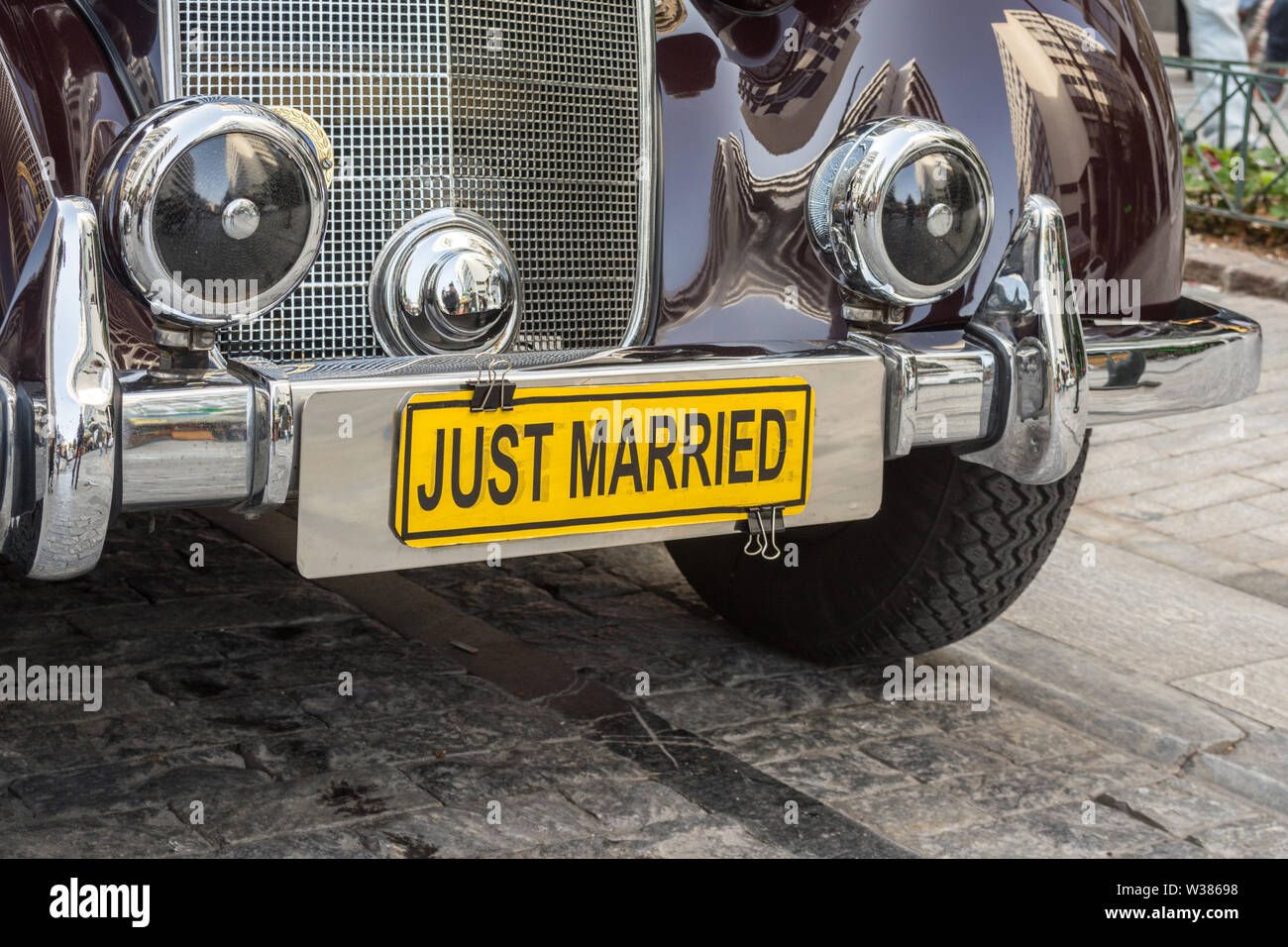 Une vieille voiture poli classique, utilisé pour le transport de mariage avec un 'jaune' juste marié - plaque street photography Banque D'Images
