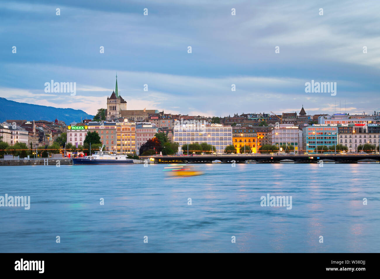 Bateau sur le Lac Léman et la vue sur le centre-ville de Genève. La cathédrale St Pierre et du Mont Salève en arrière-plan. Banque D'Images