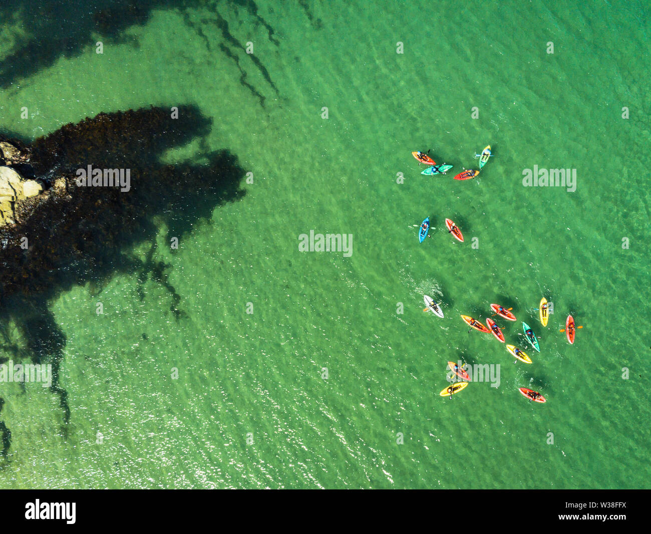 Une photographie aérienne de kayaks de mer colorés sur une eau claire comme du cristal sur l'océan Banque D'Images