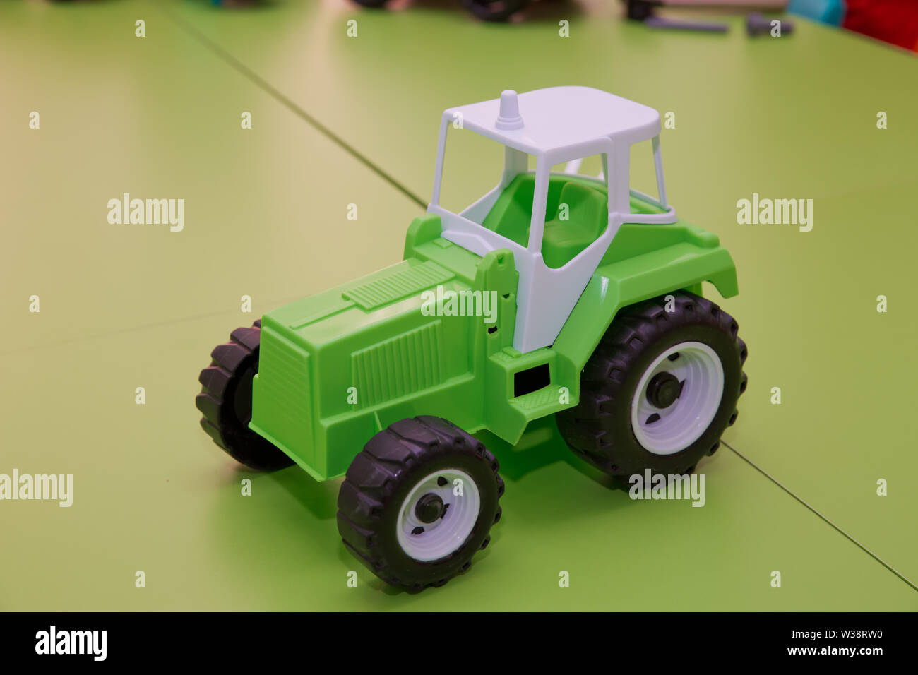 Tracteur vert. Jouet pour enfants. Tracteur jouet sur fond vert. Banque D'Images