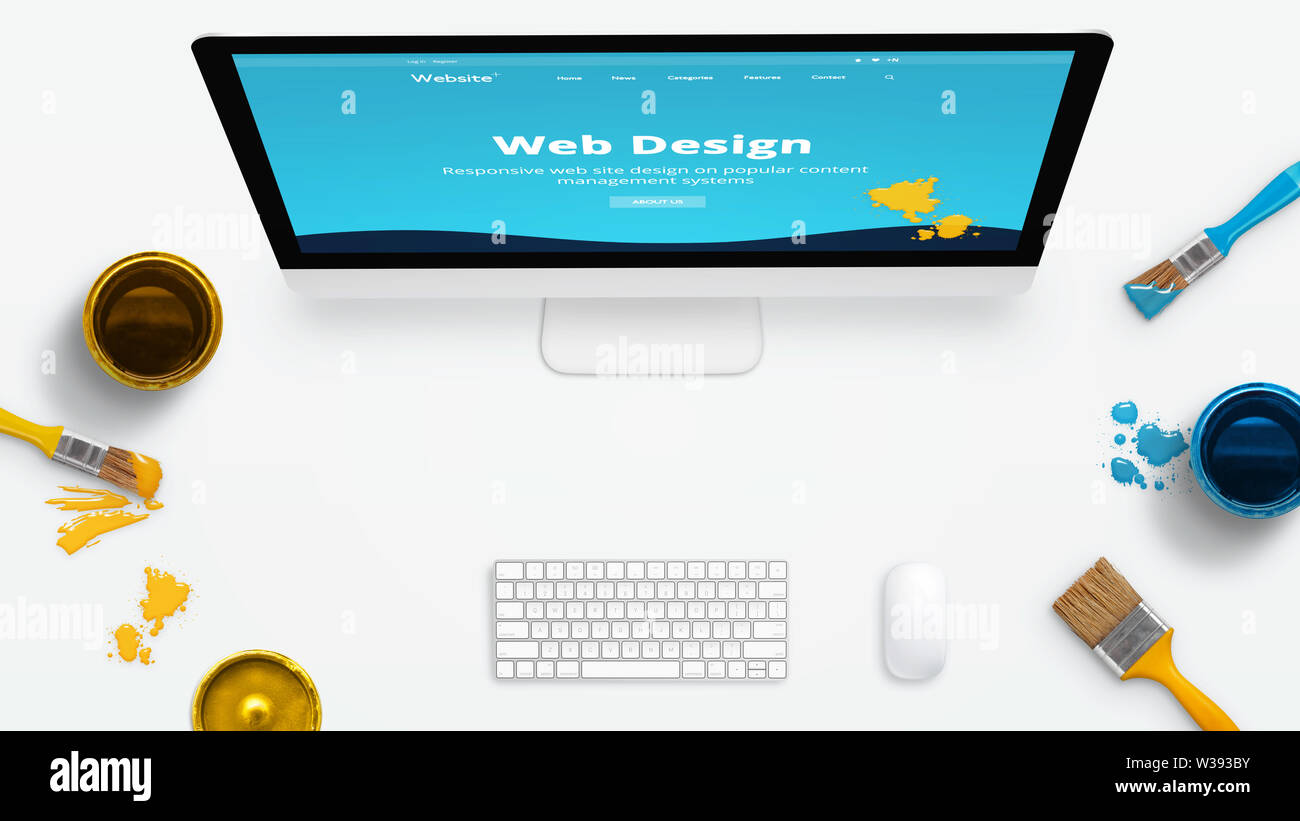 Concept d'un studio de design web moderne avec des brosses de couleur et la couleur des boîtes sur un bureau. Site web sur l'écran de l'ordinateur peinte en couleurs. Banque D'Images
