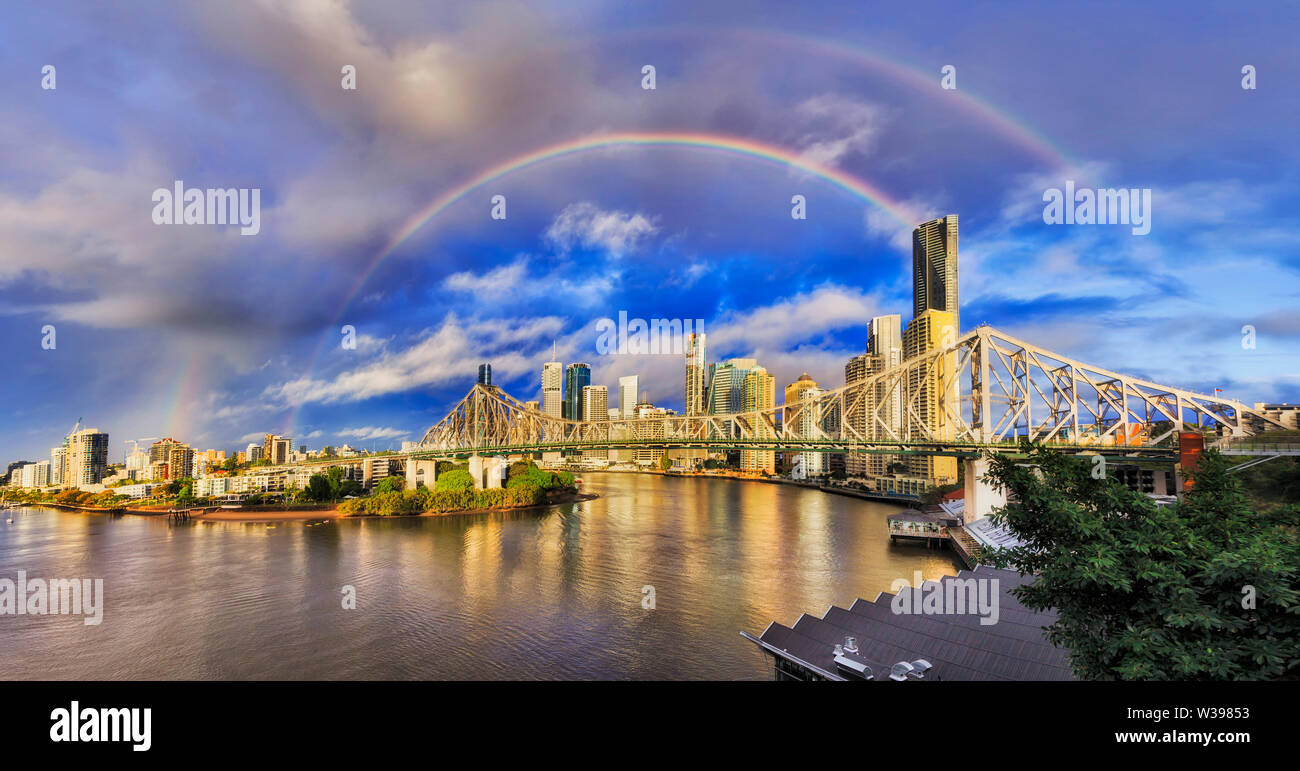 Histoire pont sur la rivière de Brisbane en face de Brisbane CBD au matin après la pluie avec double arc-en-ciel sur la ville de repère dans le ciel bleu. Banque D'Images