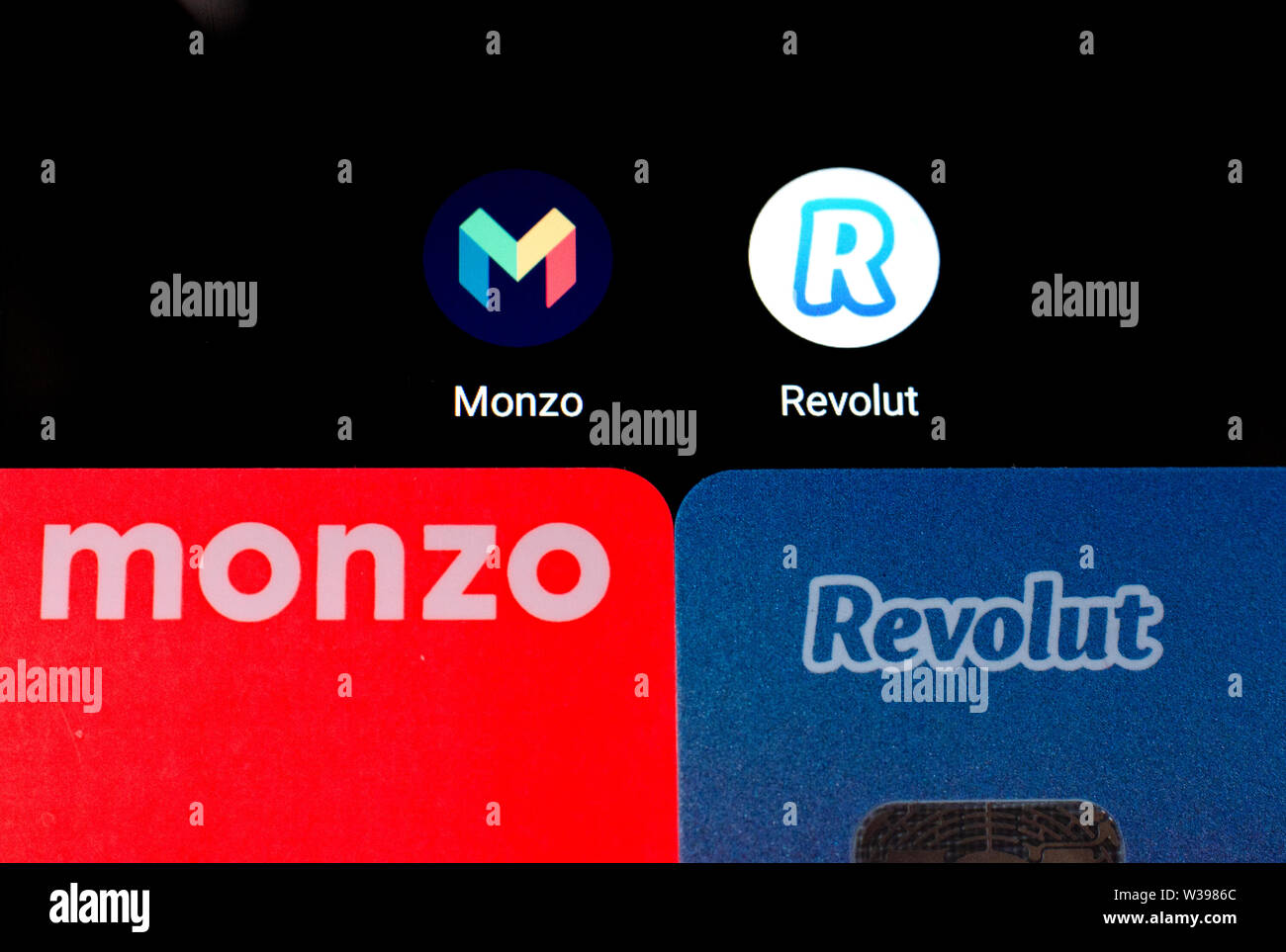 Macro photo de Monzo et Revolut cartes bancaires sur l'écran du smartphone à côté de leurs applications. Photo conceptuelle pour mettre en surbrillance la concurrence. Banque D'Images
