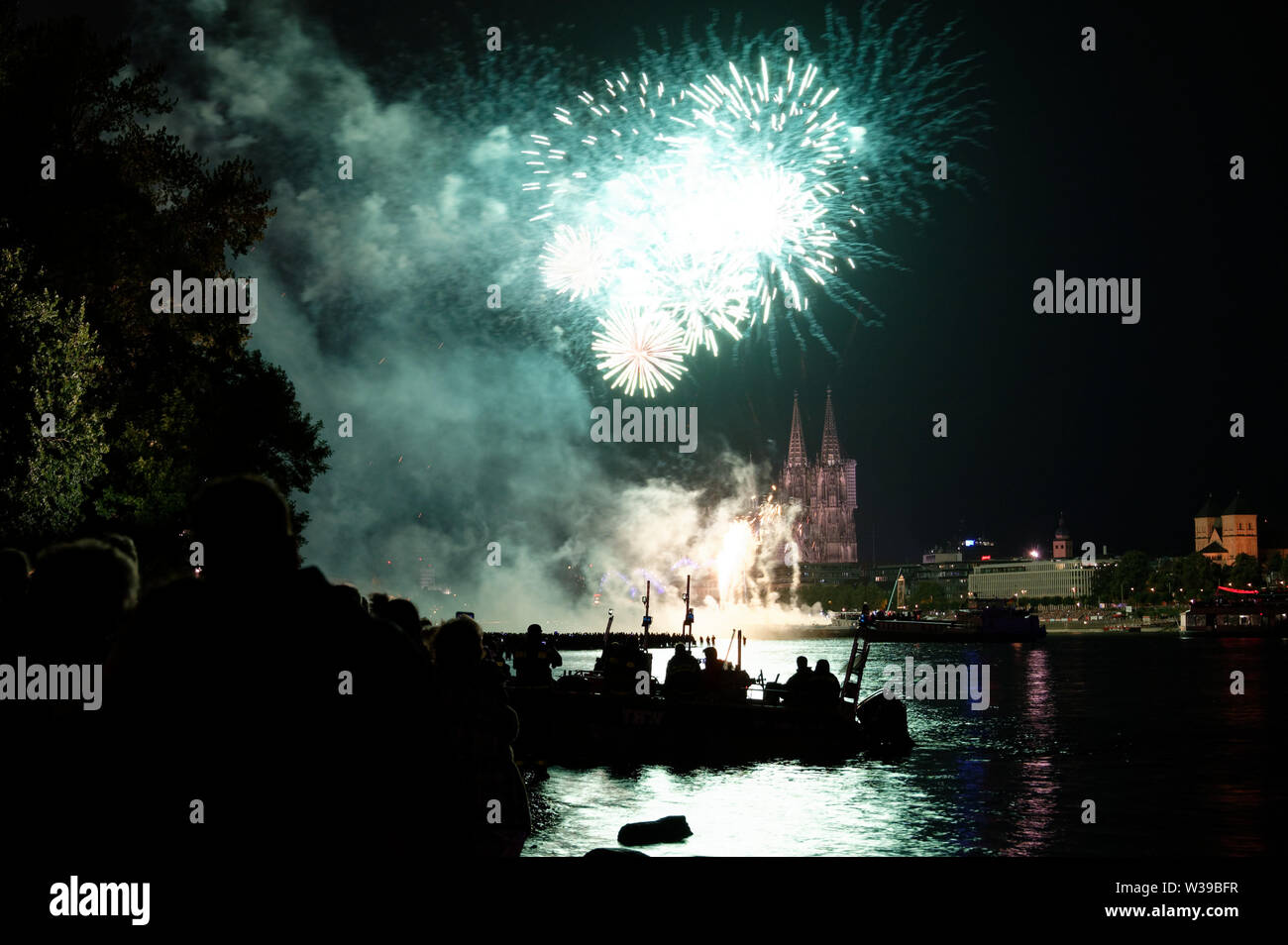 Cologne, Allemagne. Le 13 juillet, 2019. Les spectateurs suivent le grand feu d'artifice sur les rives du Rhin à la musique de Jacques Offenbach dans le cadre de la "Cologne". Credit : Henning Kaiser/dpa/Alamy Live News Banque D'Images