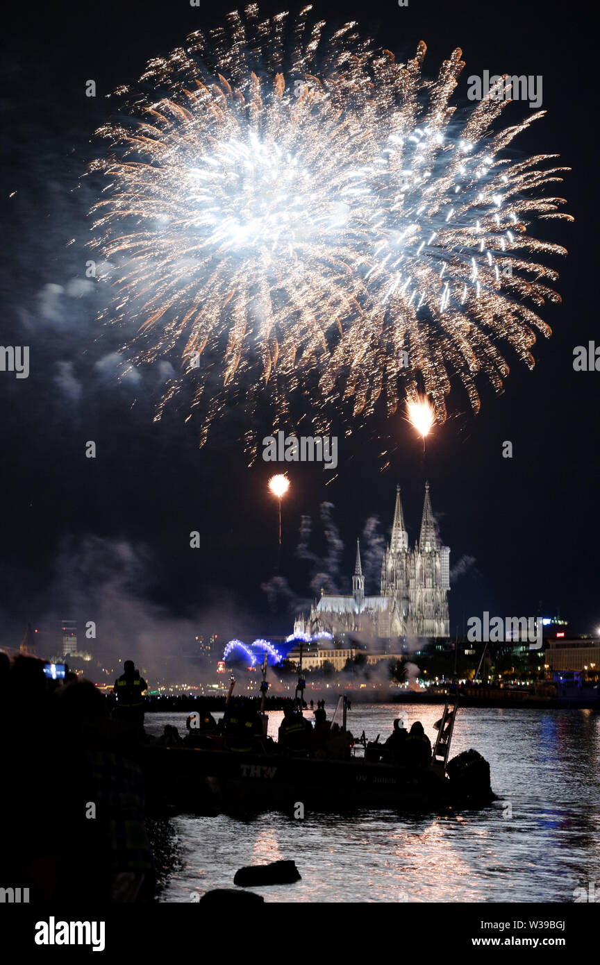 Cologne, Allemagne. Le 13 juillet, 2019. Les spectateurs suivent le grand feu d'artifice sur les rives du Rhin à la musique de Jacques Offenbach dans le cadre de la "Cologne". Credit : Henning Kaiser/dpa/Alamy Live News Banque D'Images