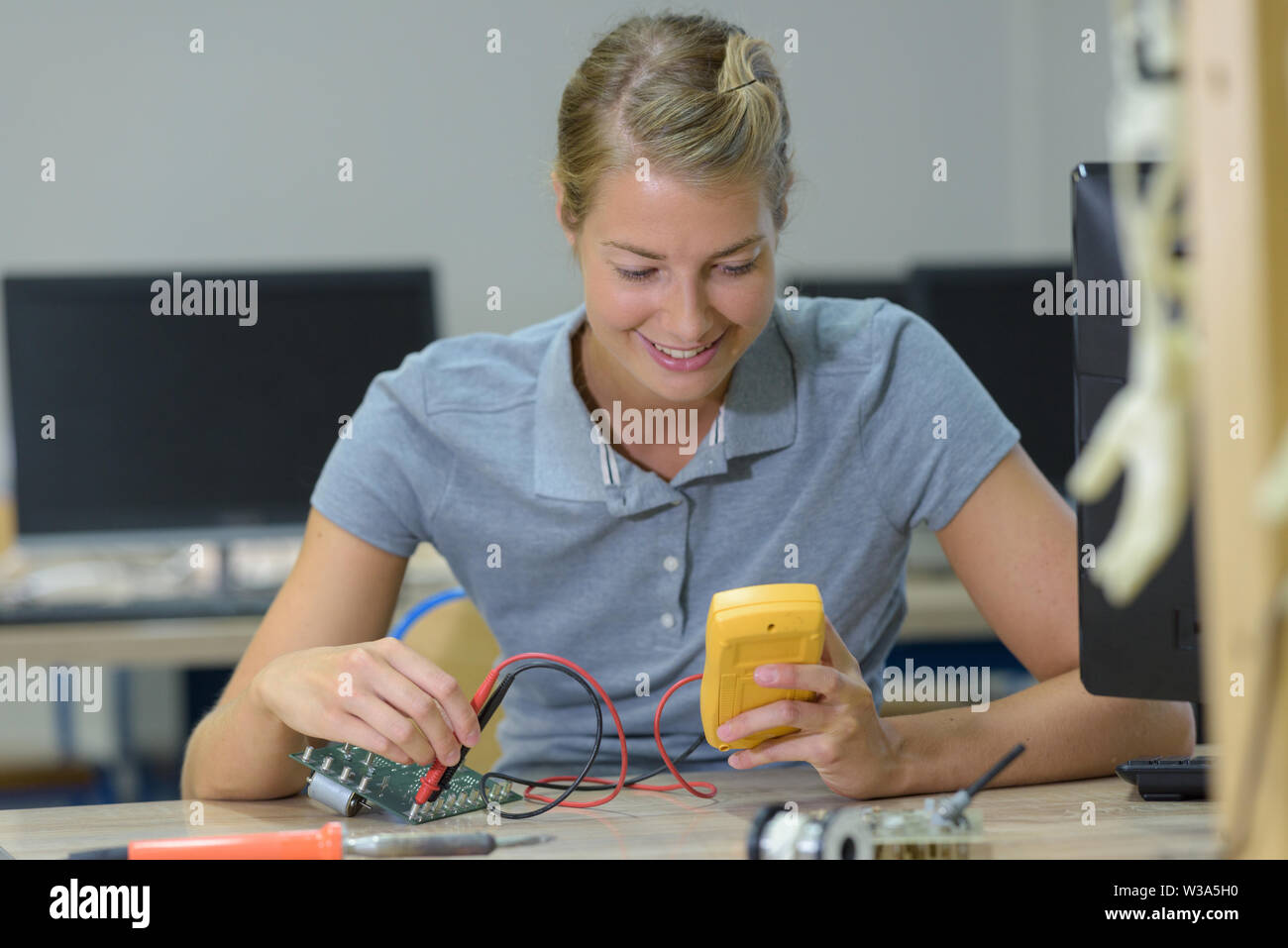 Technicien femelle à l'aide de la sonde dans le système électrique Banque D'Images