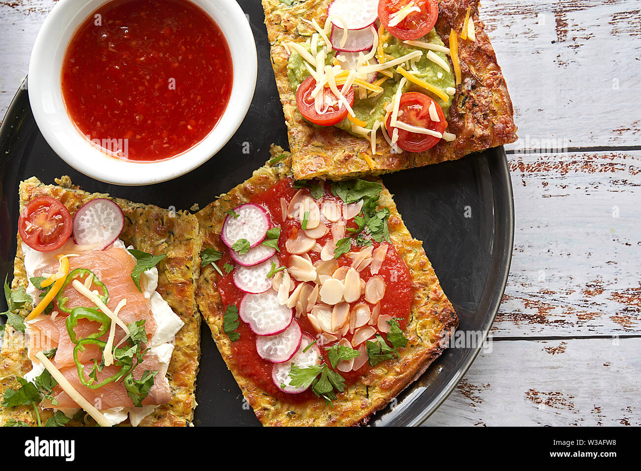 Crêpes aux courgettes et parmesan. Saumon fumé, fromage à la crème, les tomates cerises et les joints toriques de poivrons. L'avocat, fromage, salade de pommes de terre à rayures Banque D'Images