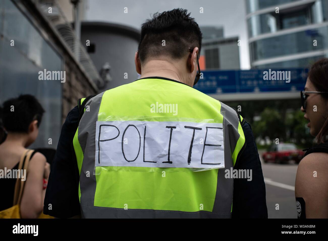 Manifestant vêtu d'un gilet fluorescent avec un mot 'poli' en référence à des actions de police contre les membres de la presse au cours d'une marche réclamant pour la liberté de la presse.Les groupes de médias et de syndicats de journalistes a organisé un "Arrêter la violence policière, défendre la liberté de la presse" marche silencieuse pour exprimer la police exige que facilite le travail des médias et le respect de la liberté de la presse. La manifestation ont été appelés après avoir subi des agressions et des professionnels des médias ont été insultés par les agents de police alors qu'ils couvraient les manifestations contre la loi sur l'extradition vers la Chine. Banque D'Images